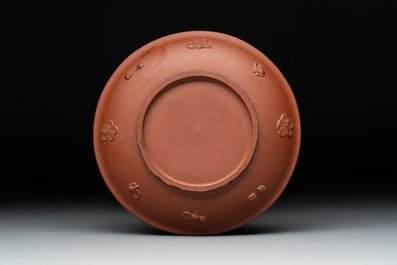 A Chinese Yixing stoneware cup and saucer with plum blossom relief design, Kangxi