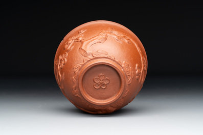 A Chinese Yixing stoneware cup and saucer with plum blossom relief design, Kangxi