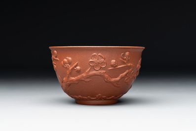 A Chinese Yixing stoneware cup and saucer with plum blossom relief design, Kangxi
