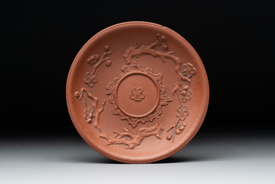 A Chinese Yixing stoneware cup and saucer with plum blossom relief design, Kangxi