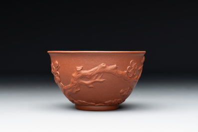 A Chinese Yixing stoneware cup and saucer with plum blossom relief design, Kangxi