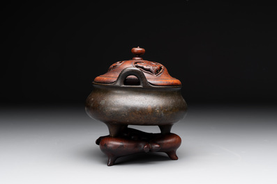 A Chinese bronze tripod censer with wooden cover and stand, Xuande mark, 18/19th C.