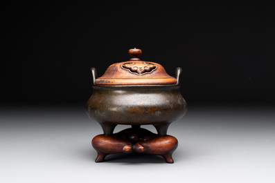 A Chinese bronze tripod censer with wooden cover and stand, Xuande mark, 18/19th C.