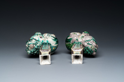 A pair of Chinese verte biscuit vases resting on Buddhist lions, Kangxi