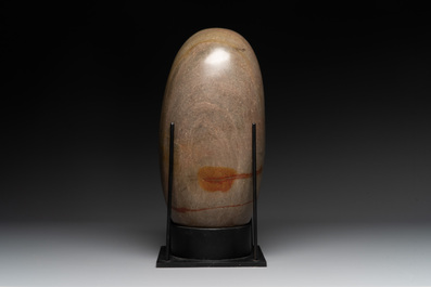 A large Shiva lingam stone on a metal stand