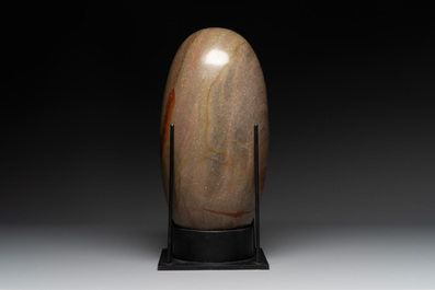 A large Shiva lingam stone on a metal stand