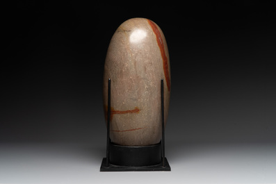 A large Shiva lingam stone on a metal stand