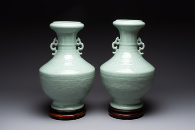 A pair of Chinese celadon-glazed vases with 'anhua' design on wooden stands, Qianlong mark, 19th C.