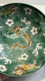 A Chinese verte biscuit 'animals among waves' bowl and a wooden stand, Jiajing mark, Kangxi
