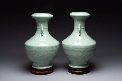 A pair of Chinese celadon-glazed vases with 'anhua' design on wooden stands, Qianlong mark, 19th C.
