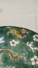 A Chinese verte biscuit 'animals among waves' bowl and a wooden stand, Jiajing mark, Kangxi