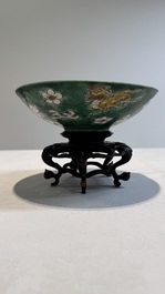 A Chinese verte biscuit 'animals among waves' bowl and a wooden stand, Jiajing mark, Kangxi
