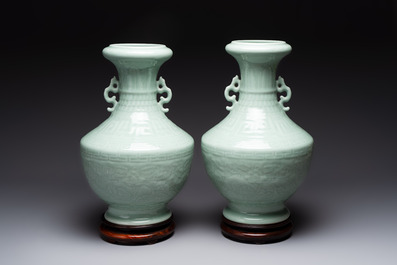 A pair of Chinese celadon-glazed vases with 'anhua' design on wooden stands, Qianlong mark, 19th C.