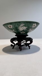 A Chinese verte biscuit 'animals among waves' bowl and a wooden stand, Jiajing mark, Kangxi