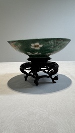 A Chinese verte biscuit 'animals among waves' bowl and a wooden stand, Jiajing mark, Kangxi