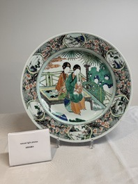 A Chinese famille verte dish with two ladies and a boy holding a lotus, artemisia leaf mark, Kangxi