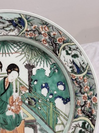 A Chinese famille verte dish with two ladies and a boy holding a lotus, artemisia leaf mark, Kangxi
