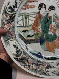 A Chinese famille verte dish with two ladies and a boy holding a lotus, artemisia leaf mark, Kangxi