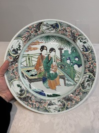 A Chinese famille verte dish with two ladies and a boy holding a lotus, artemisia leaf mark, Kangxi