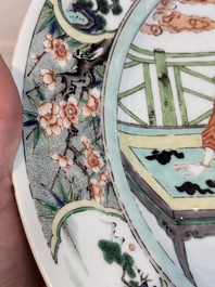 A Chinese famille verte dish with two ladies and a boy holding a lotus, artemisia leaf mark, Kangxi