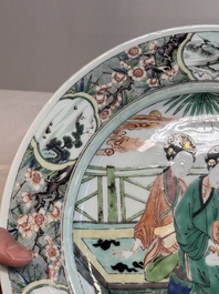 A Chinese famille verte dish with two ladies and a boy holding a lotus, artemisia leaf mark, Kangxi