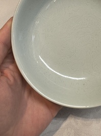 A Chinese monochrome 'anhua' 'dragon' bowl and a blue and white 'dragon' saucer, 18/19th C.