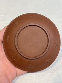 A Chinese Yixing stoneware cup and saucer with plum blossom relief design, Kangxi