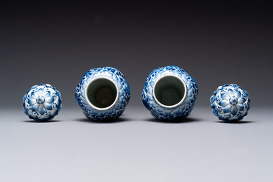 A pair of Chinese blue and white vases and covers with floral design, Kangxi