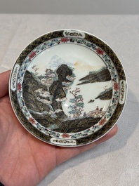 A Chinese famille rose and grisaille 'mountainous landscape' cup and saucer, Yongzheng