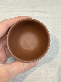 A Chinese Yixing stoneware cup and saucer with plum blossom relief design, Kangxi