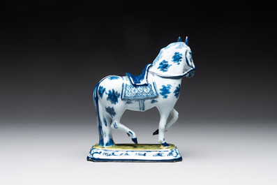 A fine pair of blue and white Dutch Delft horses on a green base, 18th C.