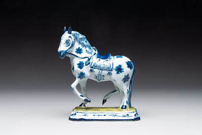A fine pair of blue and white Dutch Delft horses on a green base, 18th C.