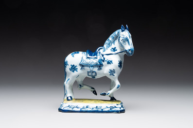 A fine pair of blue and white Dutch Delft horses on a green base, 18th C.