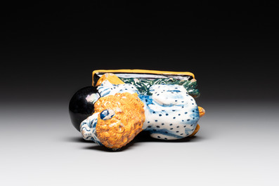 A rare black-ground polychrome Dutch Delft model of a lion with a ball, 18th C.