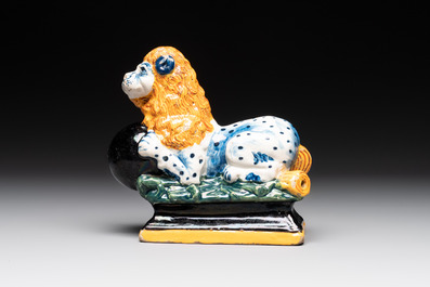 A rare black-ground polychrome Dutch Delft model of a lion with a ball, 18th C.