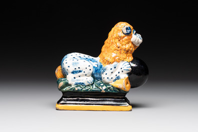 A rare black-ground polychrome Dutch Delft model of a lion with a ball, 18th C.