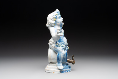 A polychrome Dutch Delft table fountain in the shape of Bacchus on a barrel, early 18th C.