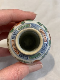 A Chinese famille rose seal paste box and a covered jarlet, a miniature wucai vase and a blue and white snuff bottle, Kangxi mark, 19/20th C.