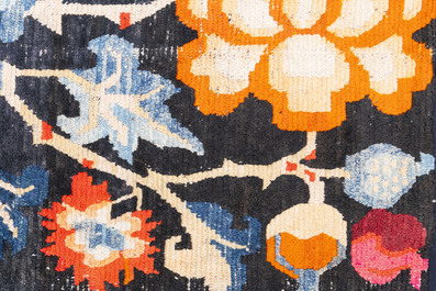 A pair of Tibetan woollen rugs with floral design, 19th C.