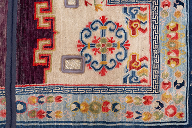 Two Tibetan saddle rugs and three small rugs, 19th C.