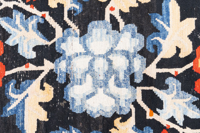 A pair of Tibetan woollen rugs with floral design, 19th C.