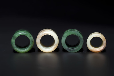 Four Chinese white and spinach-green jade archer rings and a bronze box with a crane design, 19th C.
