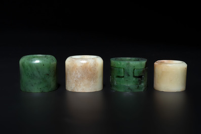 Four Chinese white and spinach-green jade archer rings and a bronze box with a crane design, 19th C.