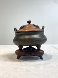 A Chinese bronze tripod censer with wooden cover and stand, Xuande mark, 18/19th C.