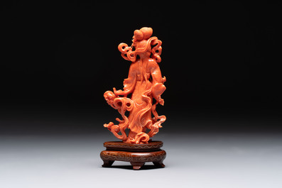 A Chinese red coral figure of a goddess on wooden stand, 19/20th C.