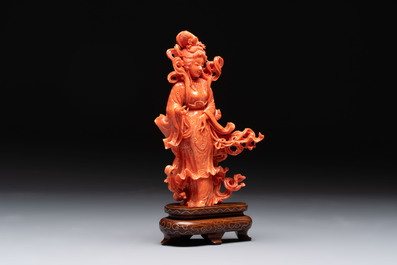 A Chinese red coral figure of a goddess on wooden stand, 19/20th C.