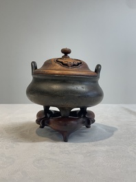 A Chinese bronze tripod censer with wooden cover and stand, Xuande mark, 18/19th C.