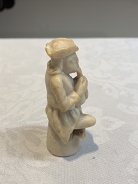 A carved alabaster figure of a seated bagpiper, Low Countries, possibly 17th C.