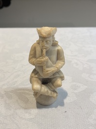 A carved alabaster figure of a seated bagpiper, Low Countries, possibly 17th C.