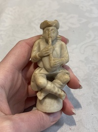 A carved alabaster figure of a seated bagpiper, Low Countries, possibly 17th C.